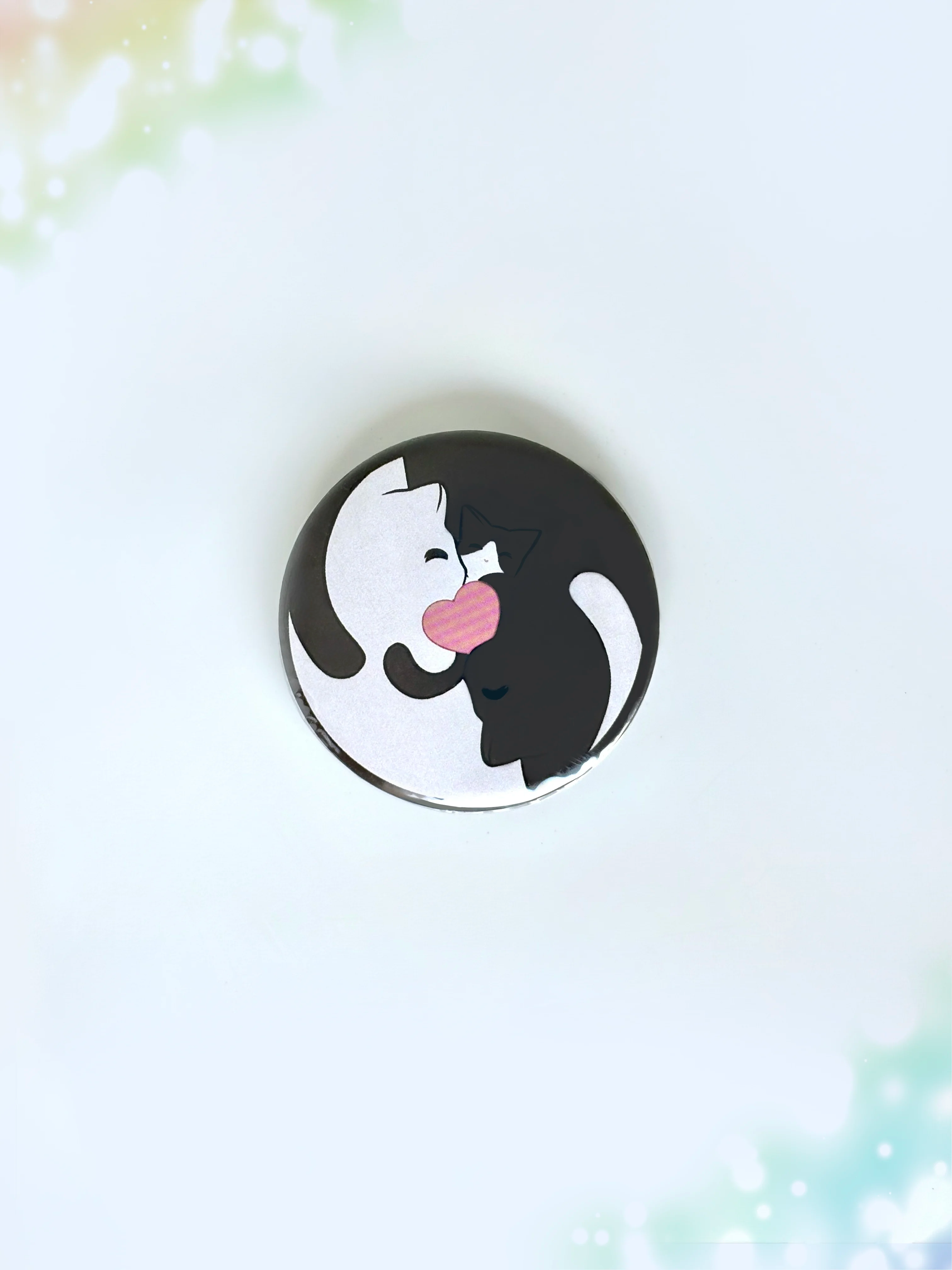 Cute anime style black and white cats cuddling together with a pink heart center button badge.