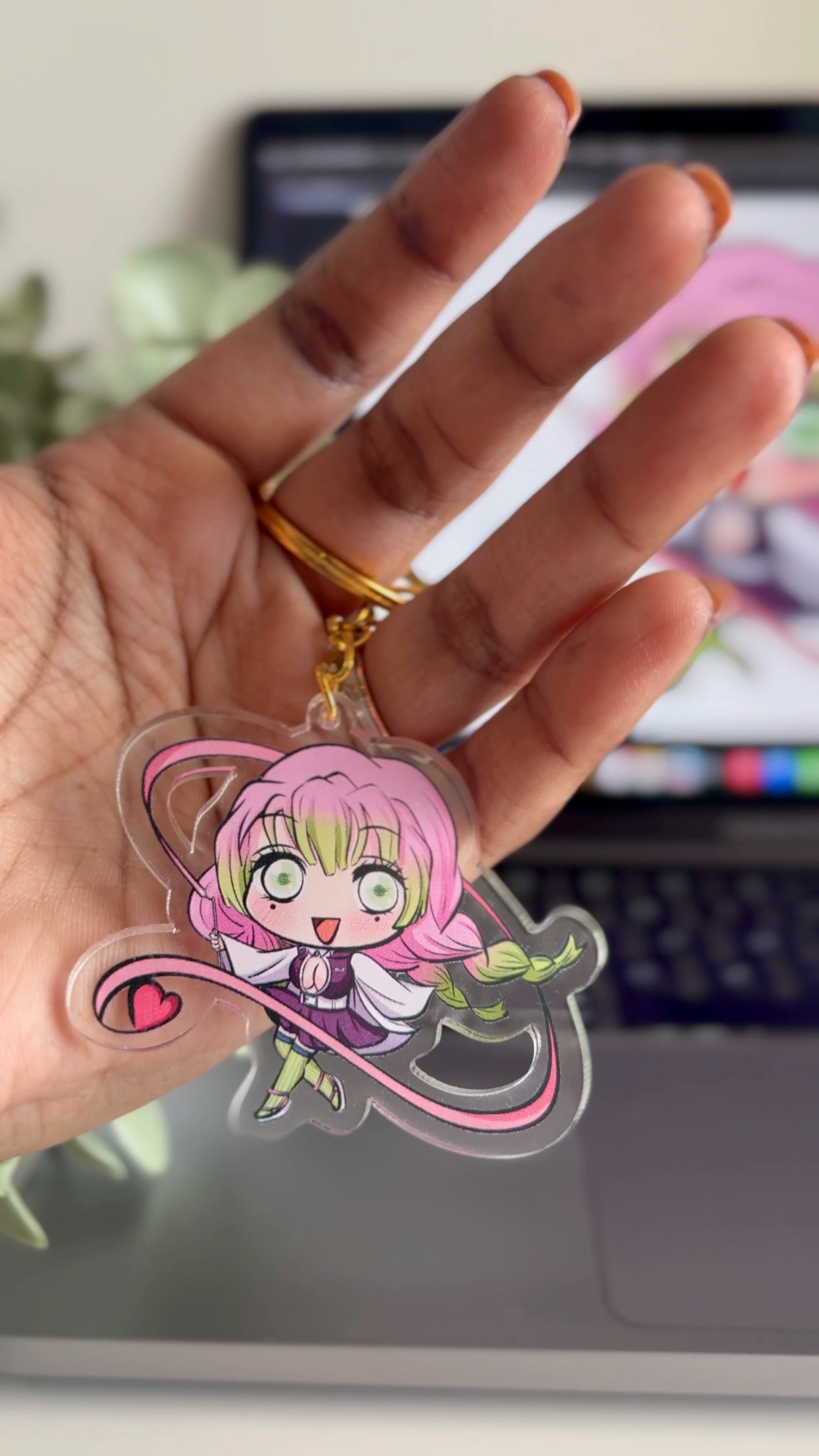Mitsuri Kanroji fanmade acrylic keychain held in hand with a blurred background